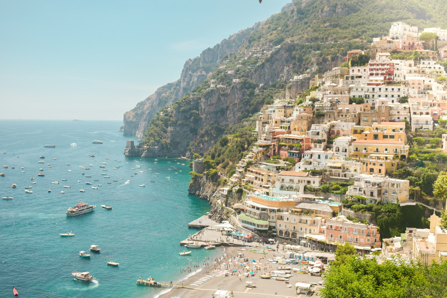 Positano houses stacked on the Amalfi coast hillside above the sea in warm daylight