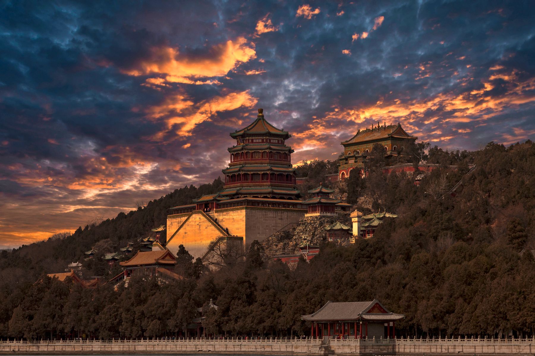 The Summer Palace in Beijing at sunset, pavilion rooflines against a golden sky