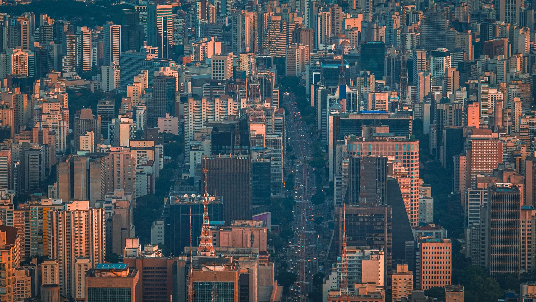Aerial view of the São Paulo skyline at dusk, towers lit against fading twilight